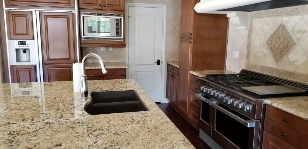Clean kitchen with polished granite counters and stainless appliances